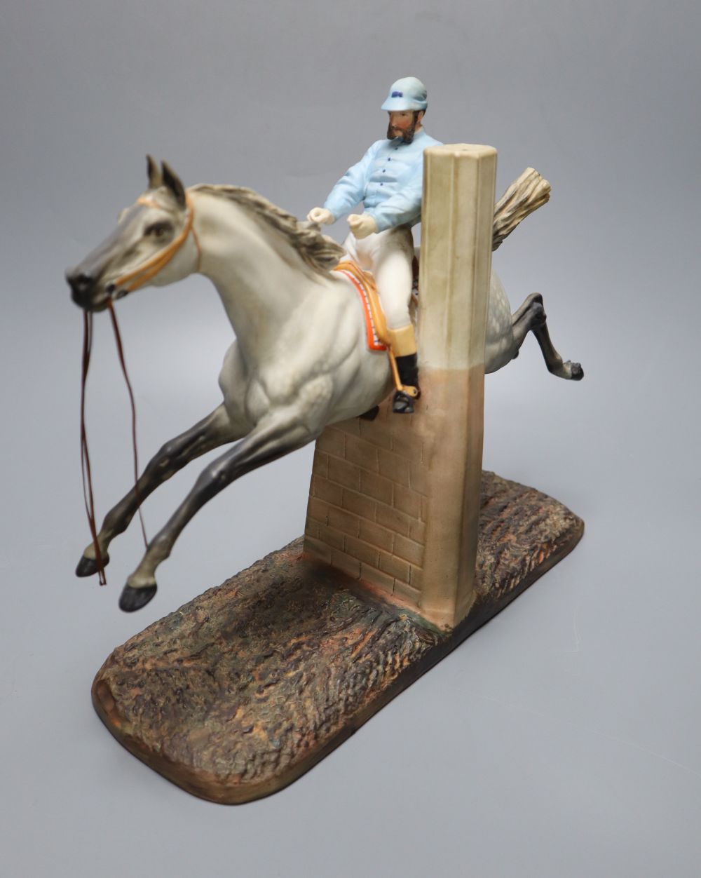 A cast coloured bisque porcelain horse and jockey group, height 26cm